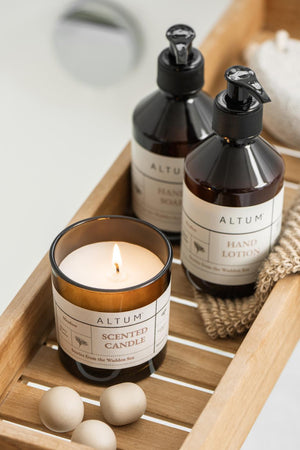 ALTUM hand lotion and matching care products arranged on a wooden tray with bathroom accessories