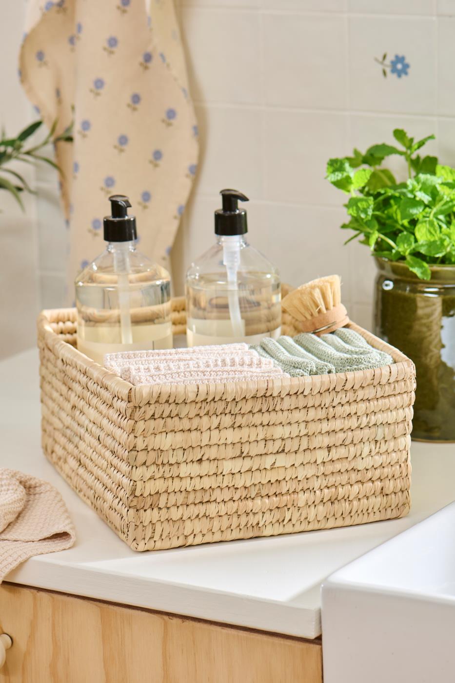Knitted washcloths from Ib Laursen in a woven basket in the bathroom