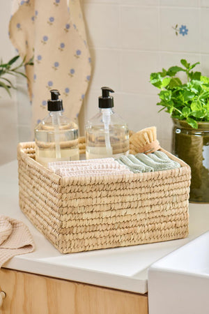 Knitted washcloths from Ib Laursen in a woven basket in the bathroom
