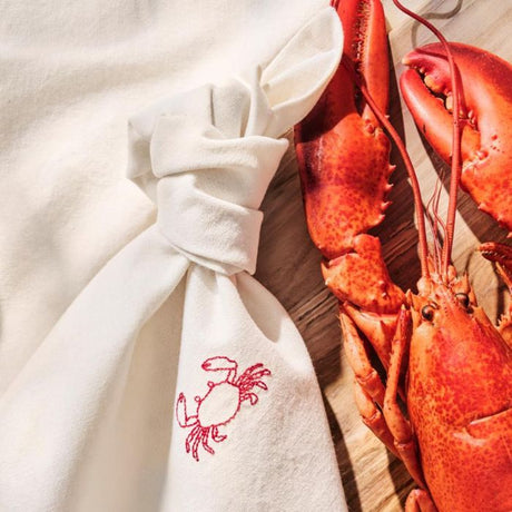 Ib Laursen Atlantis stofserviet med krabbe broderi ved siden af en hummer